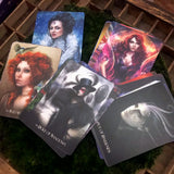 6Witch3 Divine Circus Oracle Cards - a small array of cards rests  on a circle of green moss laying on a brown wooden background