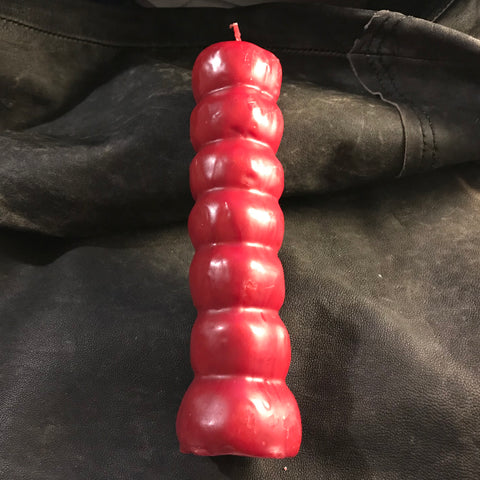 6Witch3 - red 7 knob candle shown laying on brown leather