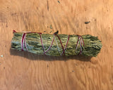 6Witch3 cedar herb bundle in the 5" size shown on a tan wood background