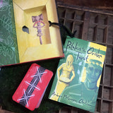 6Witch3 The Orisha Tarot - the open box is shown with the deck removed and placed facedown next to the guidebook on a circle of moss resting on a wooden background