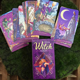 6Witch3 Teen Witch Tarot - A spread of cards and one side of the card box lay on a circle of green moss placed on a wood background.